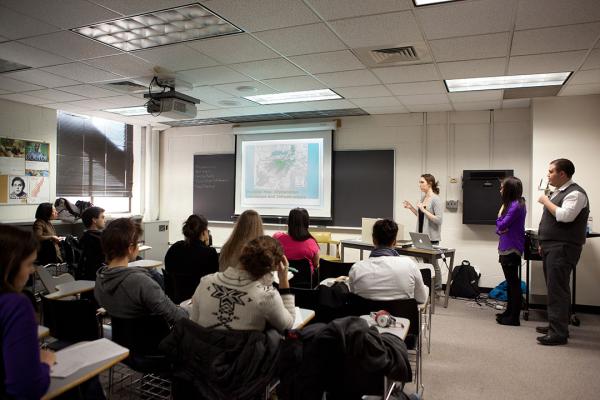 A woman stands at the front of a Peace Studies classroom lecturing to a group of students